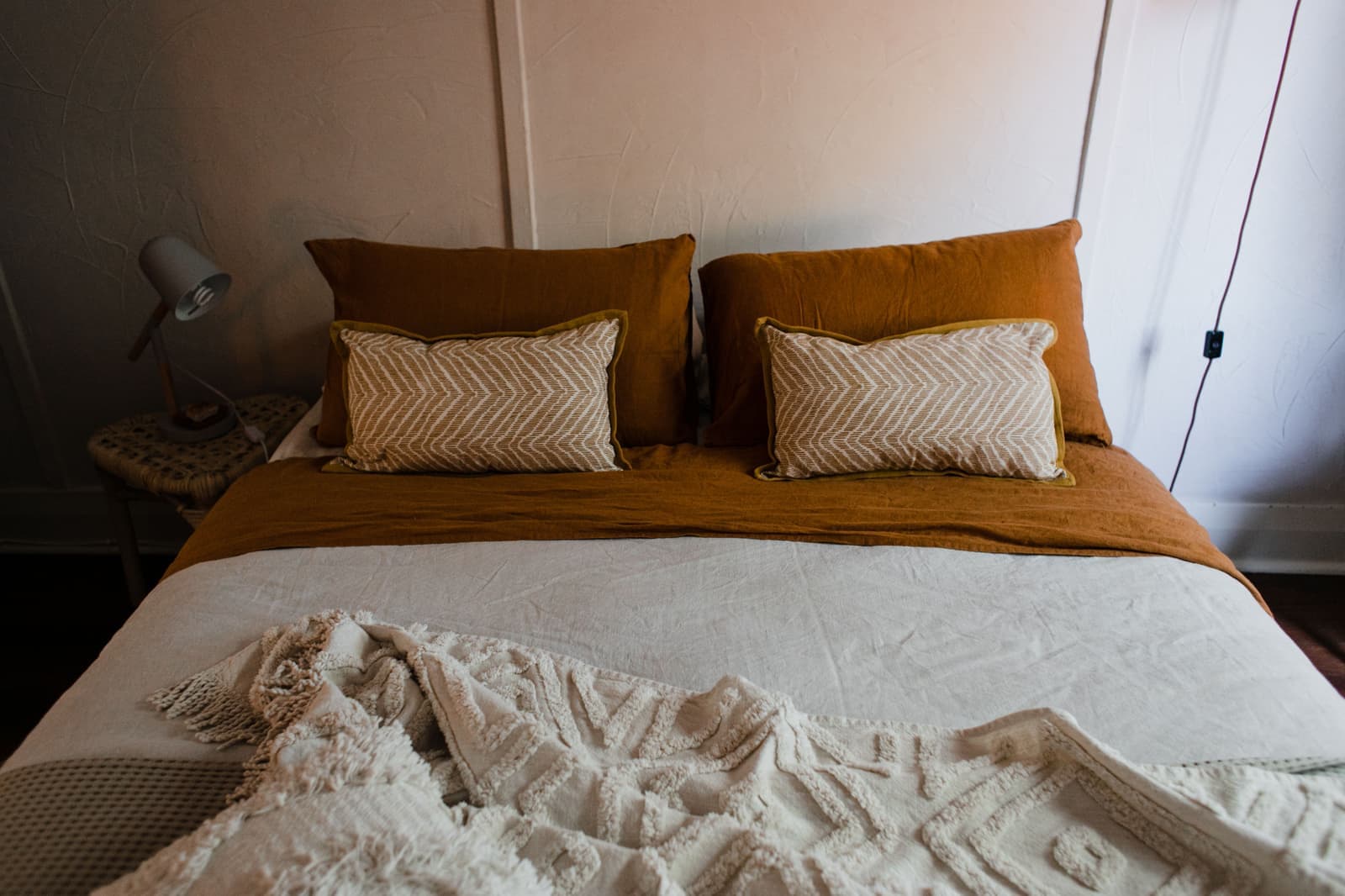 A made bed with pillows in soft evening light
