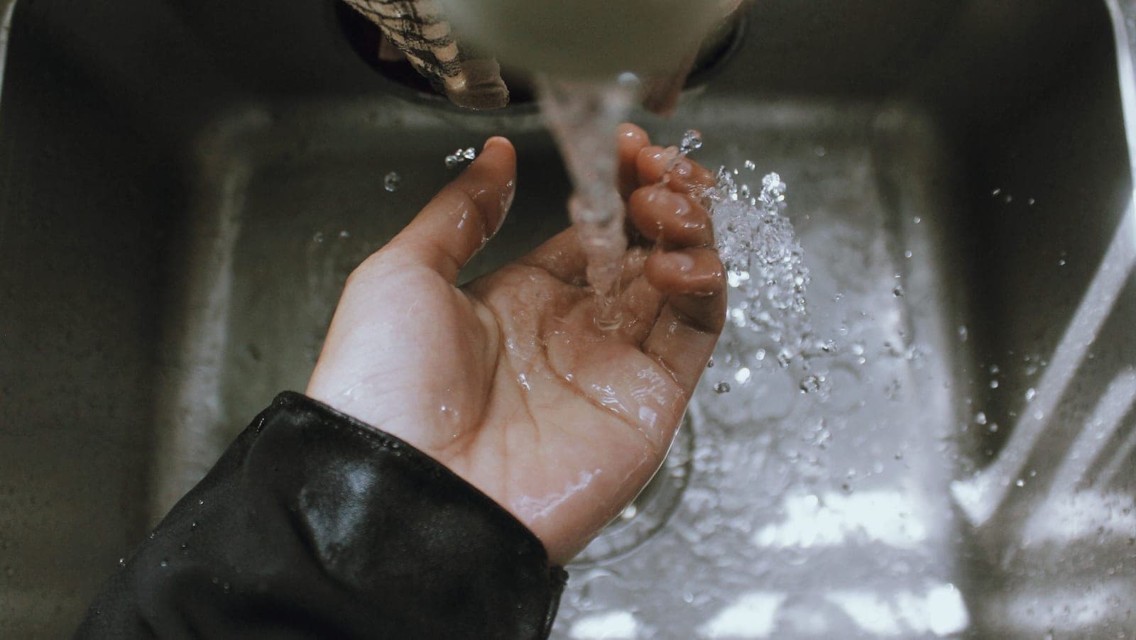 Water running over a hand at a sink